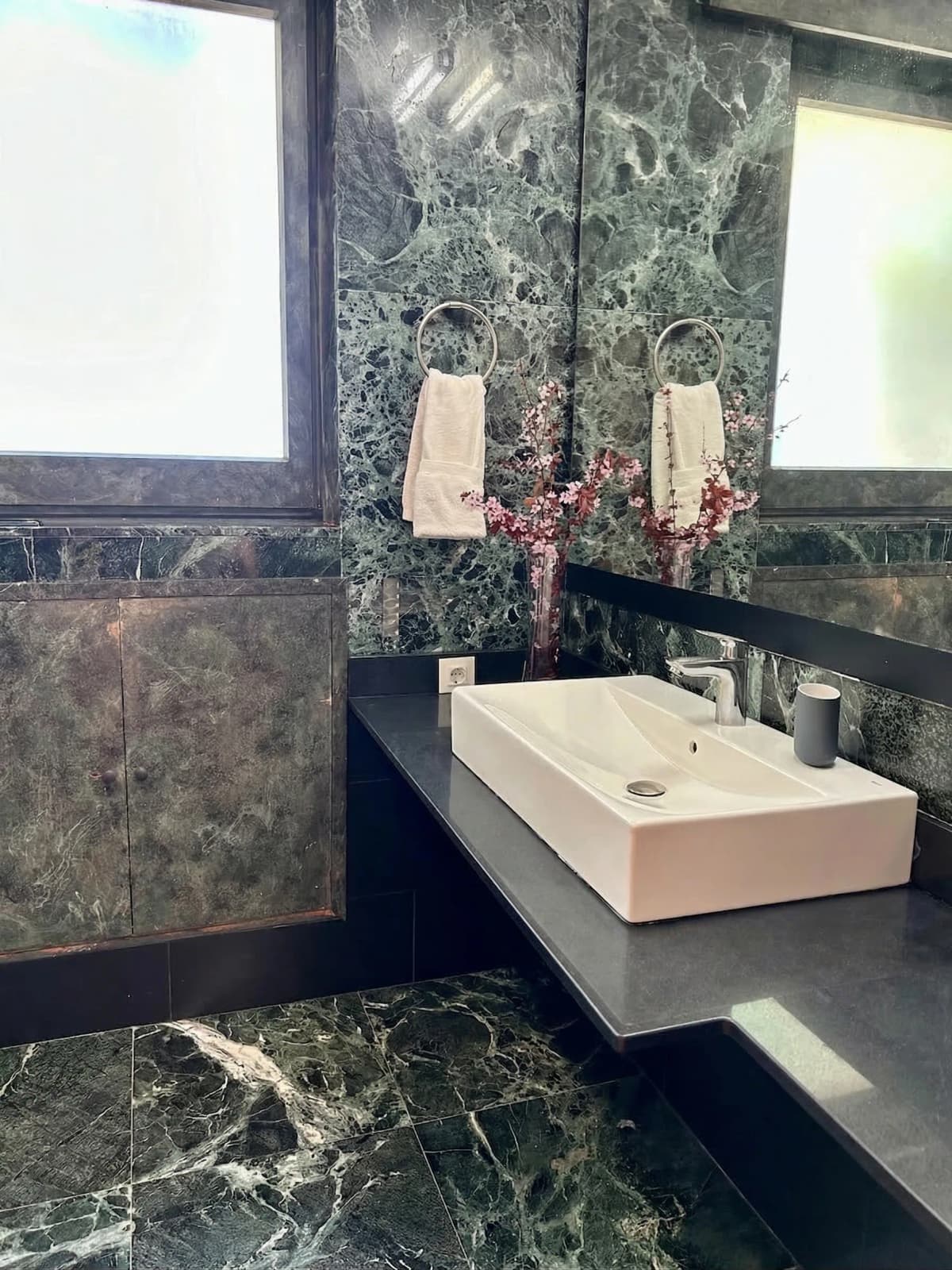 Bathroom with green marble finishes